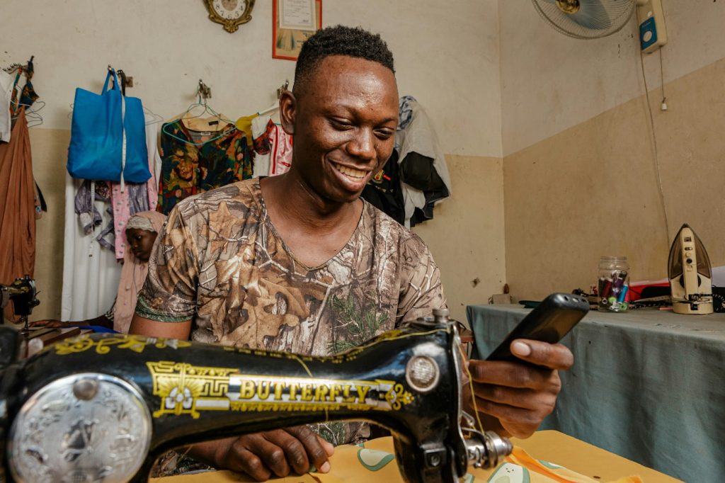 Emprendedor atendiendo a un cliente desde el móvil en su taller